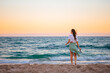 © travnikovstudio - Young happy woman on the beach at sunset enjoy her sky view
