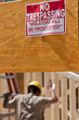 © Designpics - No Trespassing, Violators Will Be Prosecuted sign on wood beam during construction