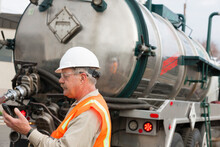 Environmental Engineer On Cell Phone With Tank Truck At Hazardous Waste Cleanup Site