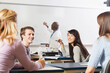 © Designpics - Students talking in an engineering class while the professor is writing on the white board