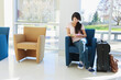 © Designpics - Girl waiting in an airport lounge and using her cell phone
