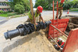 © Designpics - Construction worker preparing to lower water main section