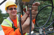 © Designpics - Cable lineman attaching a line filter at a junction box from a bucket truck