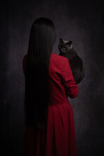 Classic Rear View Portrait Of Woman In Red Dress With A Gray Cat On Arm