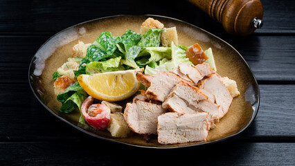 Canvas Print - Caesar salad with chicken and greens on wooden table