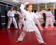 © JackF - Portrait of schoolchild girl practicing new moves with master during karate class