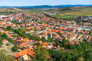 Poster - Aerial view of the town center with hills, buildings, streets, vegetation and surroundings in Rupea, Romania, 2021