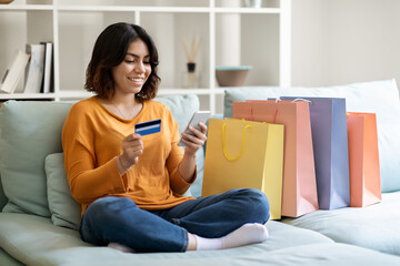 Poster - Online Shopping. Happy Arab Female Using Smartphone And Credit Card At Home