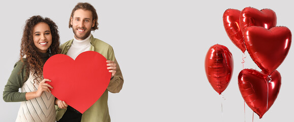 Poster - Young couple in love and heart-shaped balloons on light background. Banner for Valentine's Day celebration