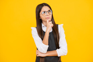 Canvas Print - Thoughtful teenage child girl on yellow background. Portrait of a kid thinking over idea. Pensive girl. Thinking face, thoughtful emotions of teenager girl.