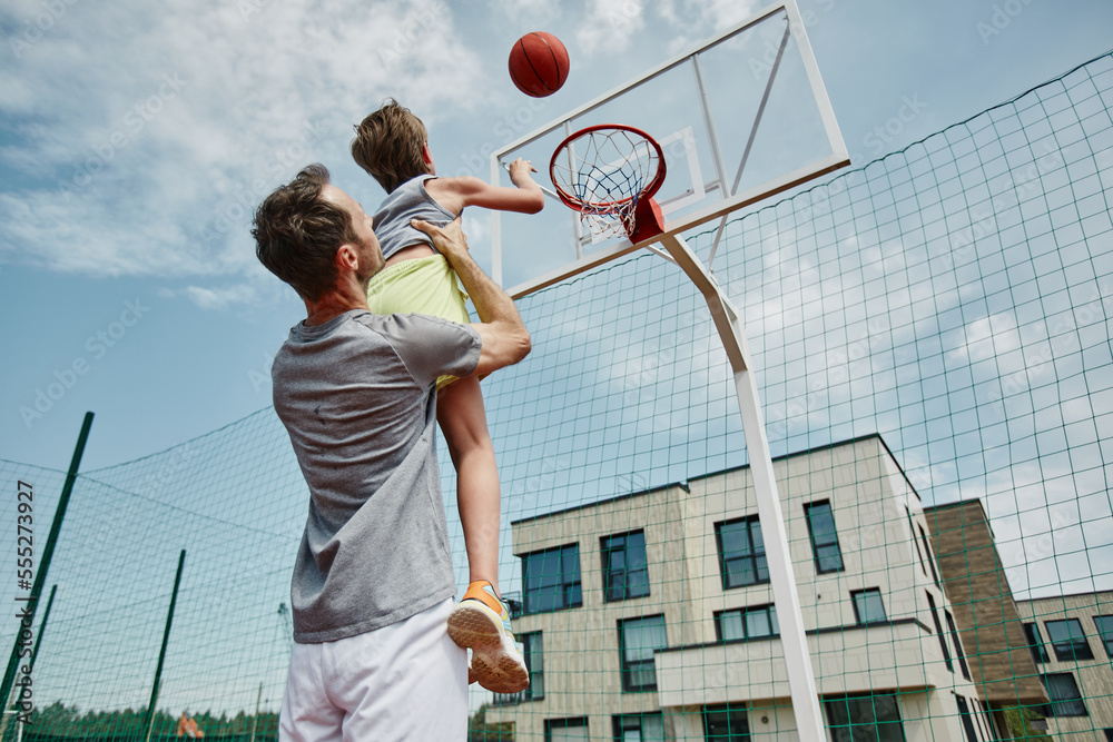low-angle-portrait-of-father-and-son-playing-basketball-together-man