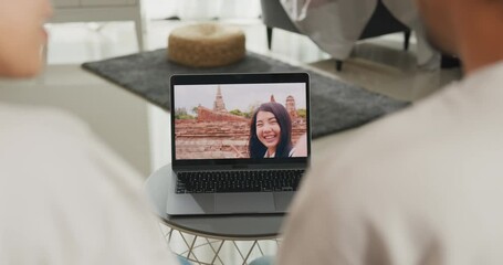 Sticker - Happy young Asian couple sit on couch smiling looking at laptop screen talk video call with friends at home on holiday. Smile young husband and wife webcam conversation using internet connection.