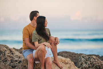 Wall Mural - Young couple on the beach vacation in Florida at sunset