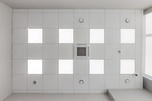 Cassette Stretched Or Suspended Ceiling With Square Halogen Spots Lamps And Drywall Construction With Fire Alarm And Ventilation In Empty Room In House Or Office. Looking Up View
