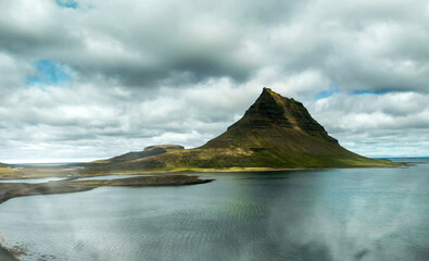 Sticker - Famous Icelandic mountain Kirkjufell with lake and ocean on the background. Kirkjufell mountain on the Snaefellsnes Peninsula in summer season from drone viewpoint