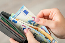 Close Up Of Female Hands Holding Grey Wallet With 20 And 50 Euro Banknotes. Purchases, Business, Finances Concept