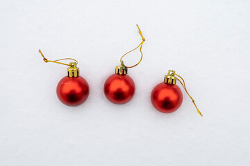 Christmas baubles in the snow, three red baubles