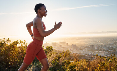 Running, black woman and fitness on sunset mountains, city background and blue sky for exercise goals, energy and power. Happy athlete, cardio and outdoor workout with motivation, smile and wellness