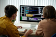 © DragonImages - Friends learning coding together, view from the back