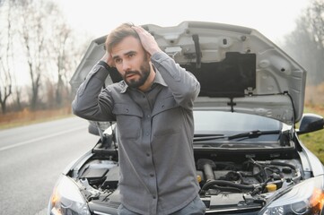 Wall Mural - Sad man on the road next to the broken car