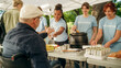© Gorodenkoff - Team of Volunteers Helping in a Local Community Food Bank, Handing Out Free Food to Low-Income People in a Park on a Sunny Day. Man with Disabilities Using Wheelchair is Thankful for Charity Meal.