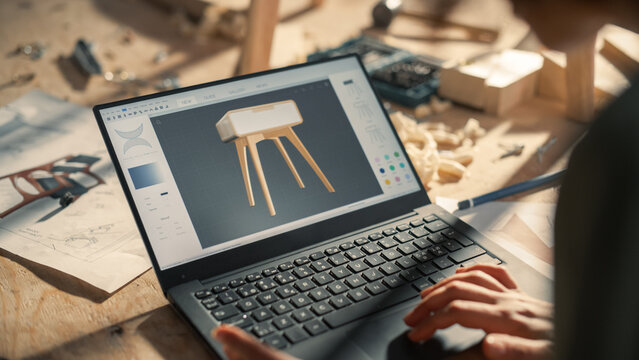 Close Up Shot of a Laptop Computer Screen with 3D Graphics Editor with Stylish Wooden Bedside Table Design. Creative Person Preparing a Furniture Item for Carpentry Project.