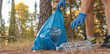 © Ezequiel Martínez - Detalle de brazos con bolsa de basura, recogiendo plástico en la montaña.