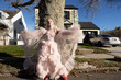 fashion portrait of non-binary person wearing pink tulle dress in suburbia