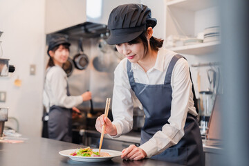 Poster - レストランのキッチンで働く2人の女性スタッフ