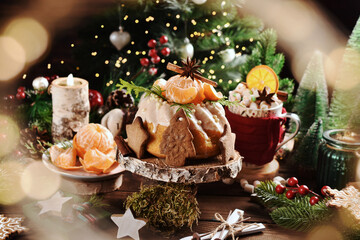 Wall Mural - Christmas table with mandarin flavored ring cake decorated with fresh fruits