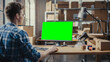 © Gorodenkoff - Young Man Using Desktop Computer with a Green Screen Chromakey Mock Up Display. Sales Manager and Employee Working in Distribution Warehouse with Cardboard Boxes. Over the Shoulder