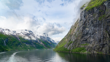  Beautiful landscape with snowy mountain peaks and waterfalls in Geiranger fjord, Norway