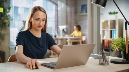 Fototapete - Creative Female Working on Laptop Computer in a Company Office. Happy Young Project Manager Browsing Internet, Writing Tasks, Developing a Marketing Strategy for a Financial Institution