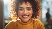 Close Up Portrait Of A Beautiful Multiethnic Middle Eastern Woman With Brown Eyes And Curly Hair. Talented Young Female Smiling Charmingly, Motivating Viewer For Better Life Choices.