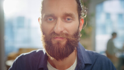 Wall Mural - Portrait of a Handsome Man in Creative Agency. Young Stylish Manager with Long Hair and a Beard Looking at Camera. Successful Manager Working in Modern Company.