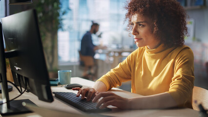 Leinwandbilder - Close Up Portrait of a Happy Middle Eastern Manager Working in Creative Office. Young Stylish Female with Curly Hair Using Computer in Marketing Agency. Cinematic Footage Through a Glass Wall.