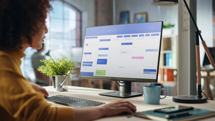 Aufkleber - Portrait of a Happy Middle Eastern Manager Working in Creative Office. Business-Driven Stylish Female with Curly Hair Using Desktop Computer with a Calendar Software on Screen Display.