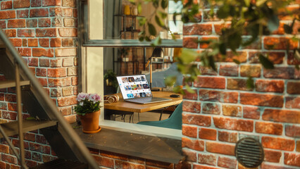 Poster - Laptop Computer with Video Streaming Platform Display on Screen Standing on a Table in Stylish Living Room. View from Outside the Window of a Brooklyn-Style Brownstone Building. Work from Home Concept