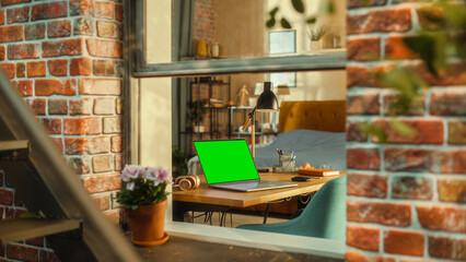 Poster - Laptop Computer with Green Screen Mock Up Display Standing on a Table in Stylish Living Room. View from Outside the Window of a Brooklyn-Style Brownstone Multi-Storey Building. Work from Home Concept.