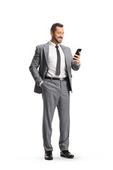 Wall Mural - Full length shot of a smiling professional man in a suit standing and looking at a smartphone