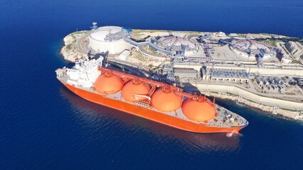 Sticker - Aerial drone top down photo of LNG (Liquified Natural Gas) tanker anchored in small gas terminal island with tanks for storage to store and regasify LNG