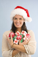 Woman Wearing Santa Hat And Holding Miniature Christmas Gifts