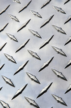 Stainless Steel Diamond Plate Facade With Reflection Of Clouds