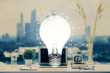 Poster - Computer on desktop in office with bulb icon hologram. Double exposure. Concept of idea.