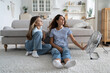 © DimaBerlin - Loving carefree mother and teenage girl sits in relaxed position on floor in living room near fan. Satisfied positive family of woman and daughter spend time at home during abnormally high temperature