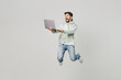 © ViDi Studio - Full body young caucasian happy surprised excited amazed IT man wear mint hoody jump high hold use work on laptop pc computer isolated on plain solid white background studio. People lifestyle concept.