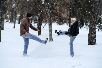 Valentines day outdoors celebration date ideas. Winter love story. Cold season dating for couples. Young couple in love play snowball, hugging and kissing in winter city street and park