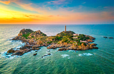 Landscape of small island with ancient lighthouse at sunrise sky is beautiful and peaceful. This is only ancient lighthouse is located on island in Vietnam