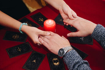 Two young friends making a Lenormand tarot session holding hand in hand.