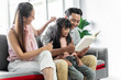 © SKW - asian family portrait Parents and daughters are happily reading together on the sofa in the house together